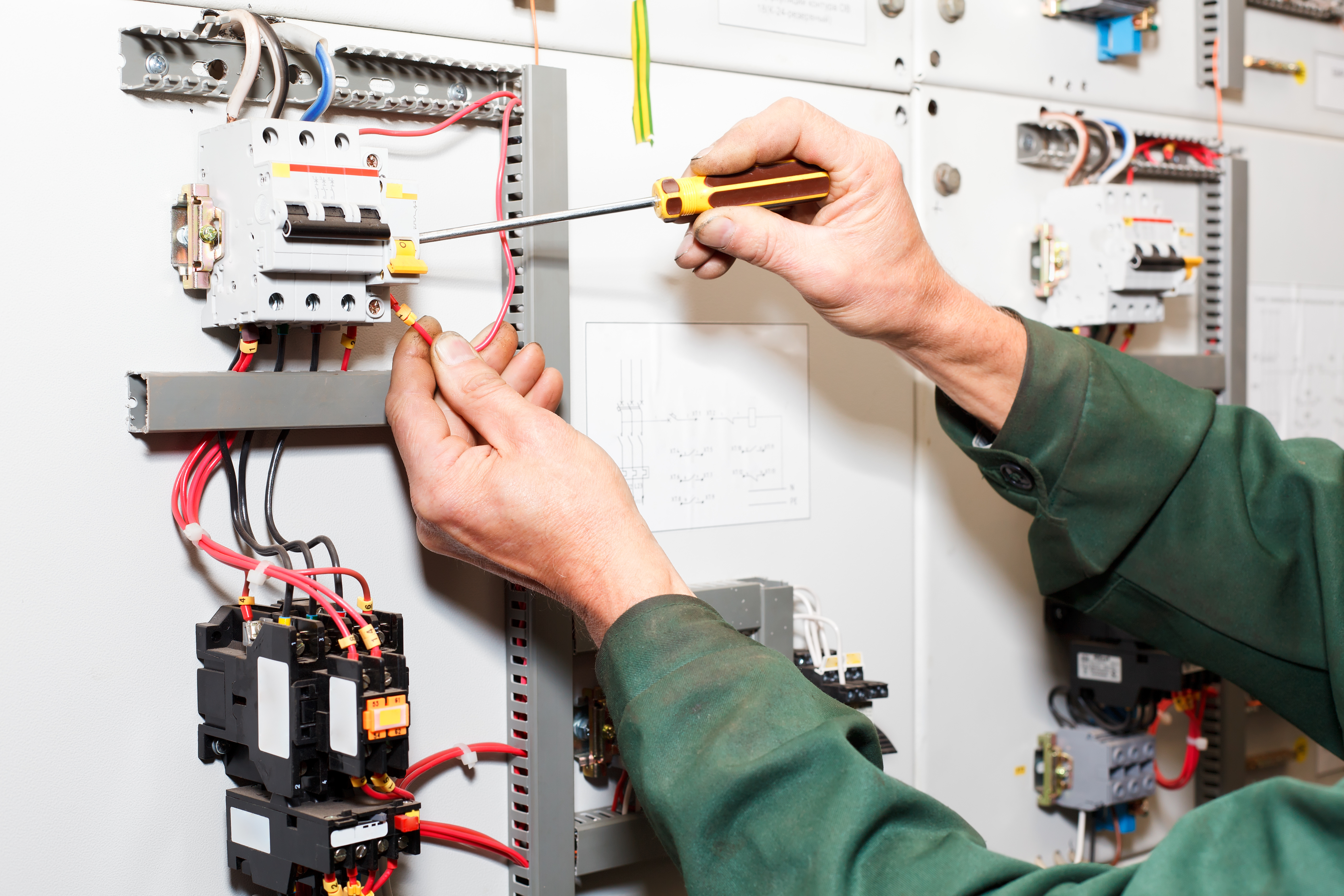Electrician`s hands working with screwdriver in cables and wires